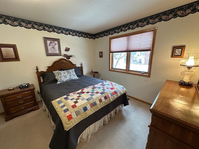 bedroom featuring light carpet and a textured ceiling