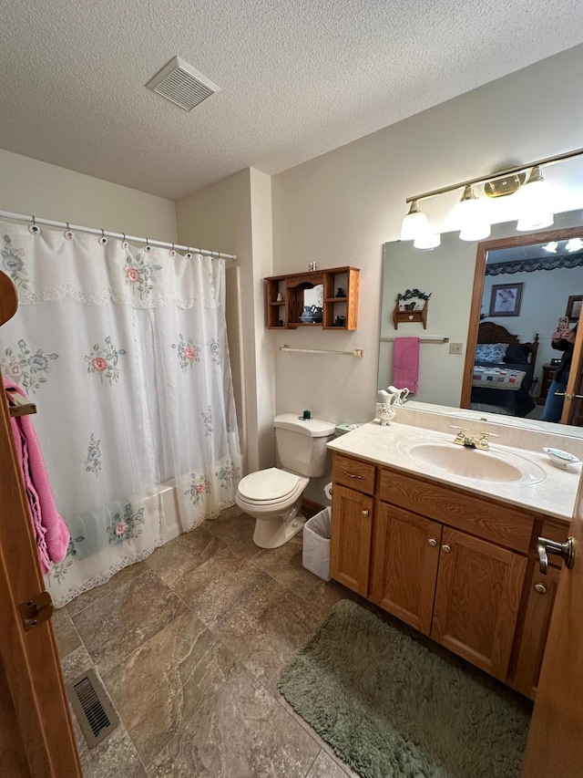 full bathroom with vanity, a textured ceiling, shower / bath combo, and toilet