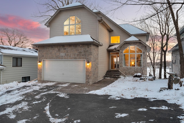 view of front of property featuring a garage and stone siding