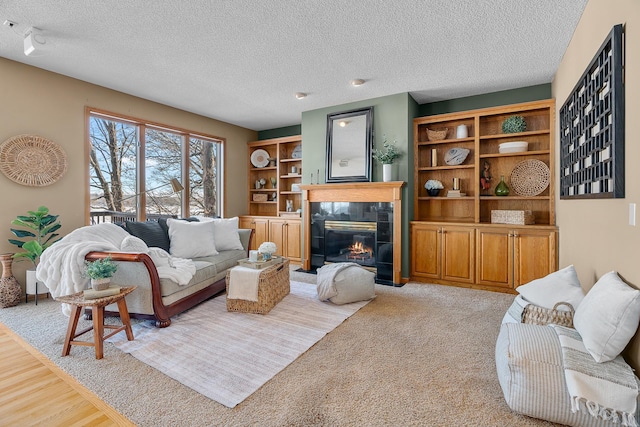 living room featuring a textured ceiling, a tiled fireplace, and light colored carpet