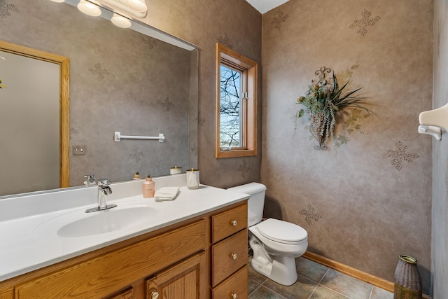 bathroom with tile patterned flooring, vanity, and toilet