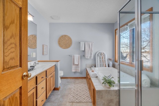 full bath with a textured ceiling, tile patterned flooring, toilet, vanity, and a bath