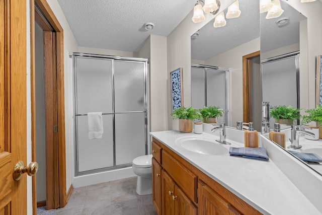 full bath with toilet, a shower stall, vanity, and a textured ceiling