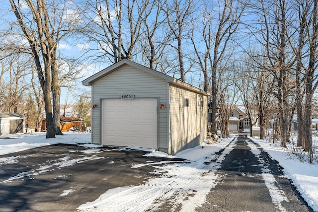 snow covered garage with a detached garage