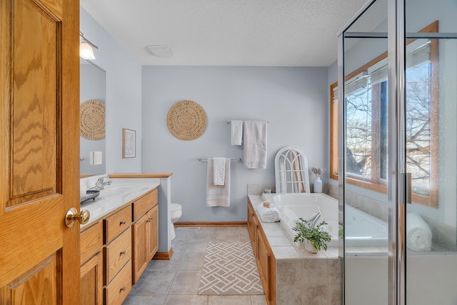 full bathroom with tile patterned floors, a garden tub, vanity, baseboards, and toilet