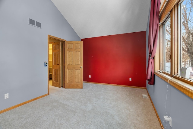 spare room featuring vaulted ceiling, carpet, and baseboards