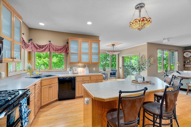 16091 Northwood Rd NW, Prior Lake, MN 55372 - kitchen with black appliances, light countertops, a kitchen bar, a textured ceiling, and a kitchen island