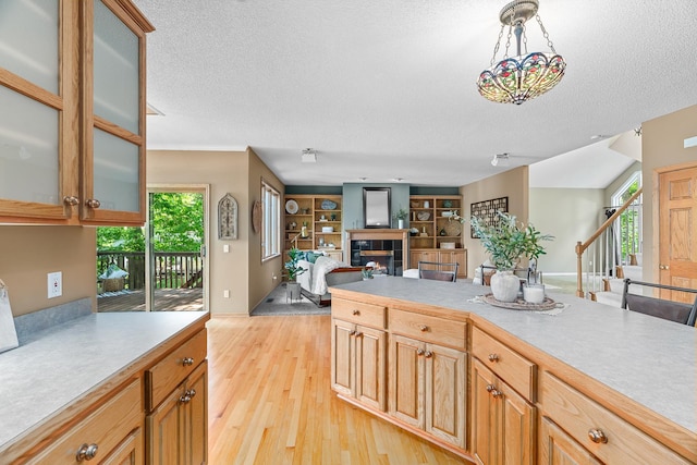 16091 Northwood Rd NW, Prior Lake, MN 55372 - kitchen featuring a textured ceiling, a fireplace, light wood-type flooring, light countertops, and open floor plan