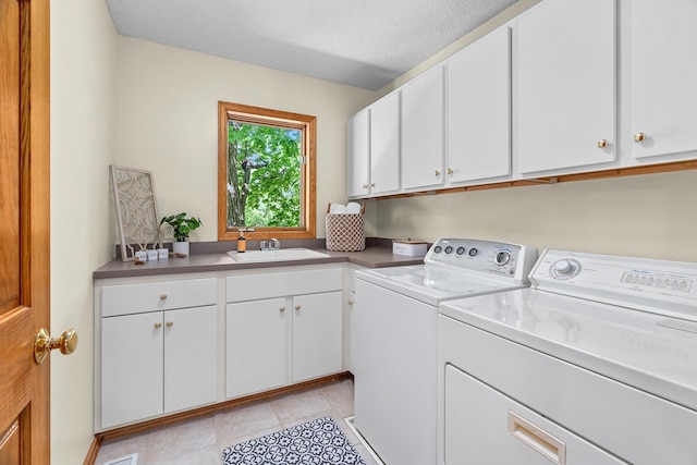 16091 Northwood Rd NW, Prior Lake, MN 55372 - washroom featuring washer and dryer, cabinet space, a textured ceiling, and light tile patterned floors