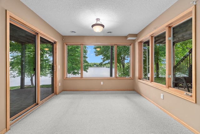 16091 Northwood Rd NW, Prior Lake, MN 55372 - unfurnished sunroom with carpet floors, a textured ceiling, and a water view
