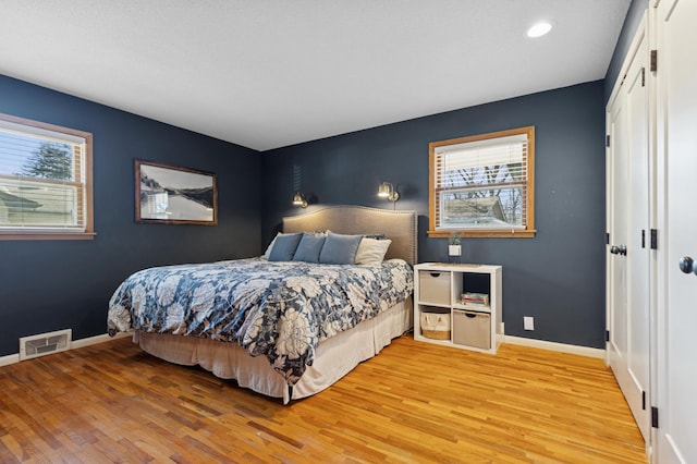 bedroom with recessed lighting, light wood-type flooring, visible vents, and baseboards