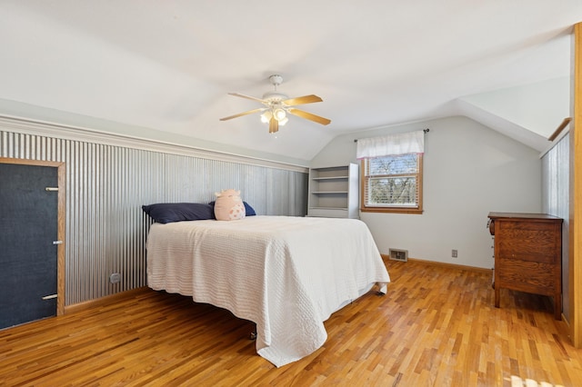 bedroom featuring lofted ceiling, light wood finished floors, baseboards, and a ceiling fan