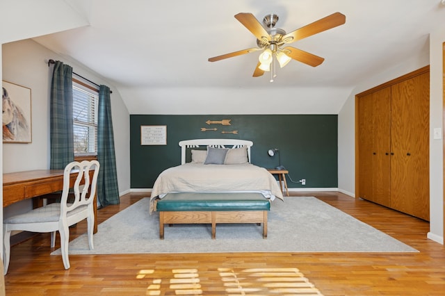 bedroom with lofted ceiling, ceiling fan, wood finished floors, and baseboards