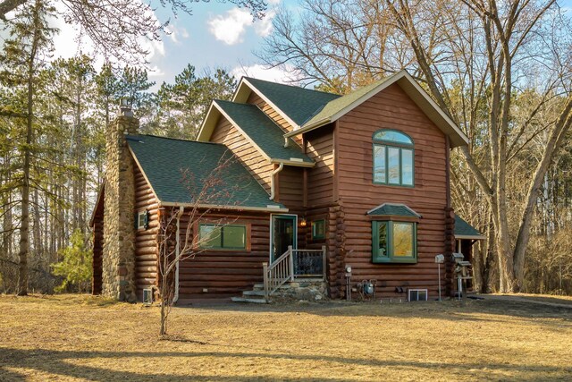 log home with a chimney, roof with shingles, and log exterior