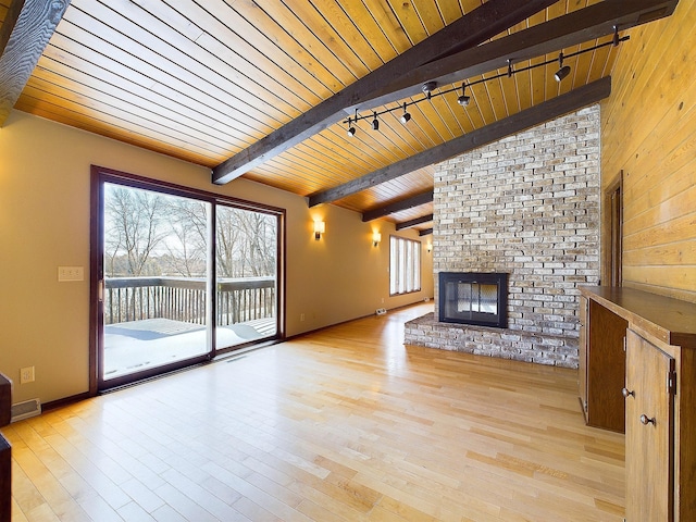 unfurnished living room with vaulted ceiling with beams, a fireplace, light hardwood / wood-style floors, track lighting, and wooden ceiling