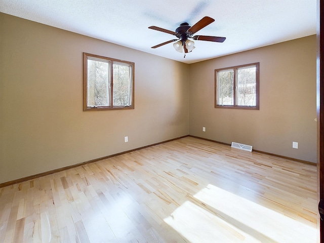 unfurnished room with ceiling fan, light hardwood / wood-style floors, and a textured ceiling