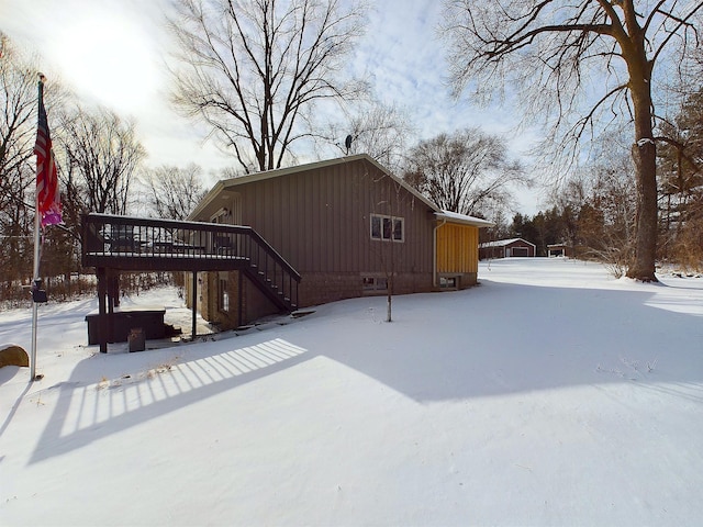 snow covered house with a wooden deck