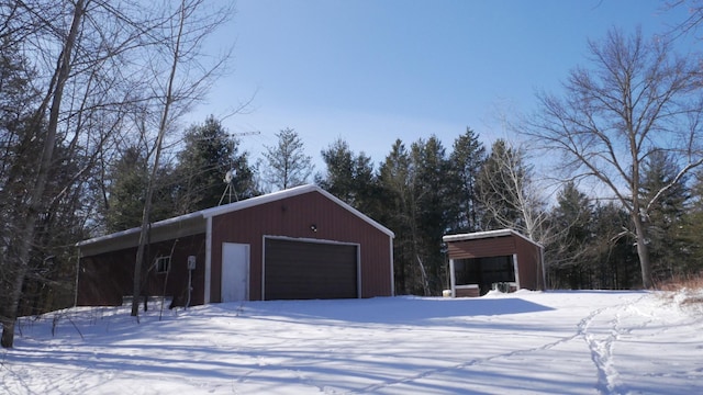 snow covered garage featuring a carport