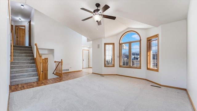 unfurnished living room with visible vents, baseboards, carpet floors, ceiling fan, and vaulted ceiling