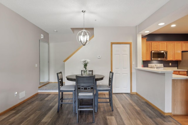 dining space featuring dark hardwood / wood-style floors, a chandelier, and a textured ceiling