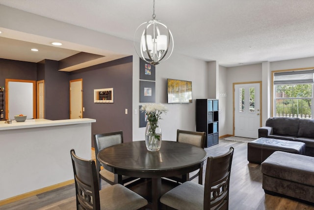 dining room featuring an inviting chandelier, dark hardwood / wood-style floors, and a textured ceiling