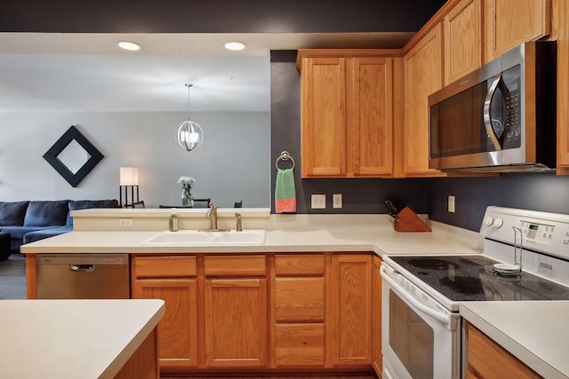 kitchen with sink, a chandelier, hanging light fixtures, kitchen peninsula, and stainless steel appliances