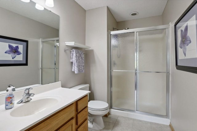 bathroom featuring tile patterned floors, toilet, a shower with shower door, and vanity