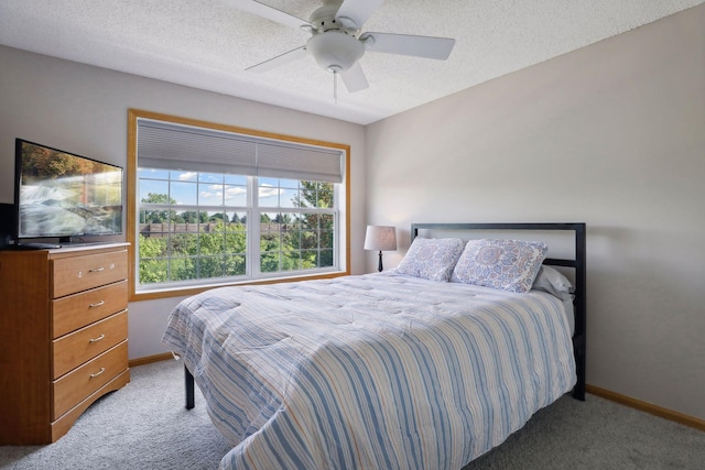 bedroom with ceiling fan, light colored carpet, and a textured ceiling