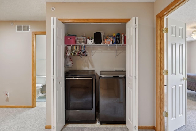 laundry area featuring light colored carpet and washing machine and clothes dryer