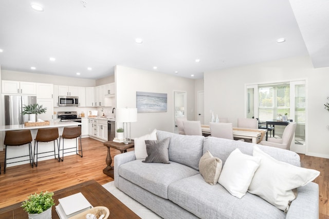 living room featuring sink and light hardwood / wood-style floors