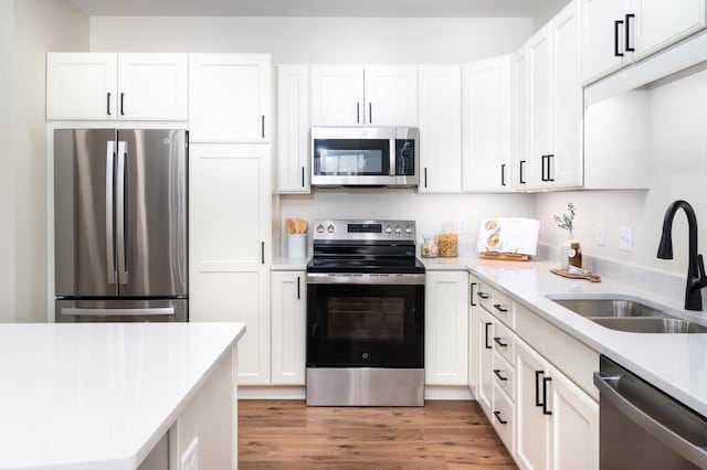 kitchen with sink, stainless steel appliances, dark hardwood / wood-style floors, and white cabinets