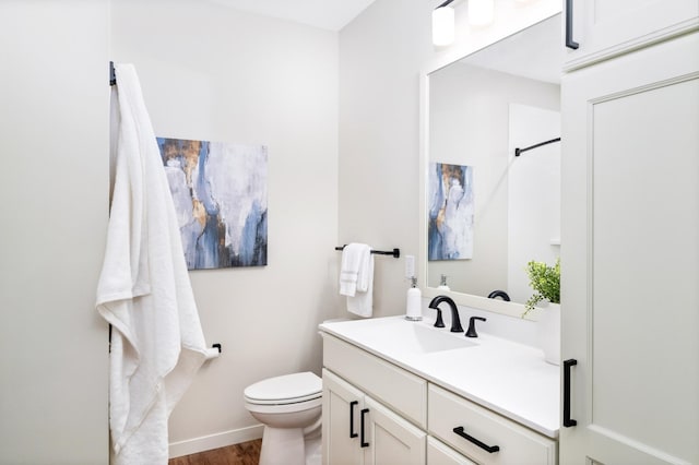 bathroom with vanity, hardwood / wood-style flooring, and toilet