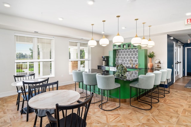 dining space with indoor bar and light parquet flooring