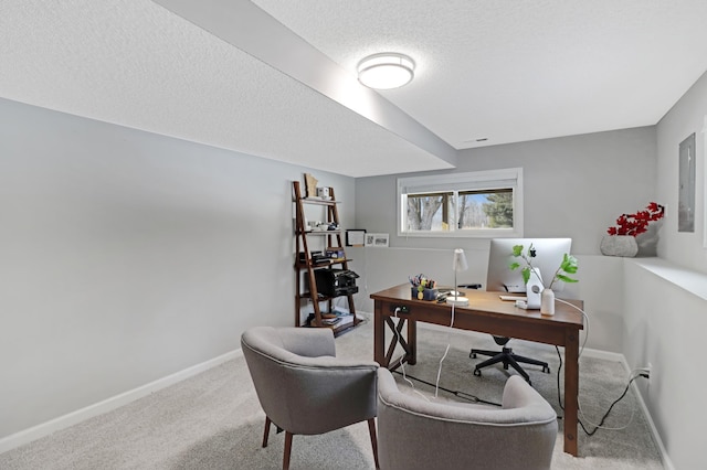 carpeted home office featuring a textured ceiling