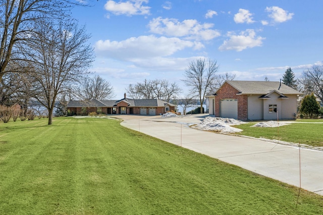 view of yard with a garage and concrete driveway