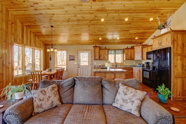 living area featuring wooden ceiling, an inviting chandelier, and vaulted ceiling