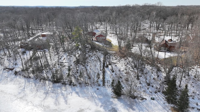 snowy aerial view featuring a forest view