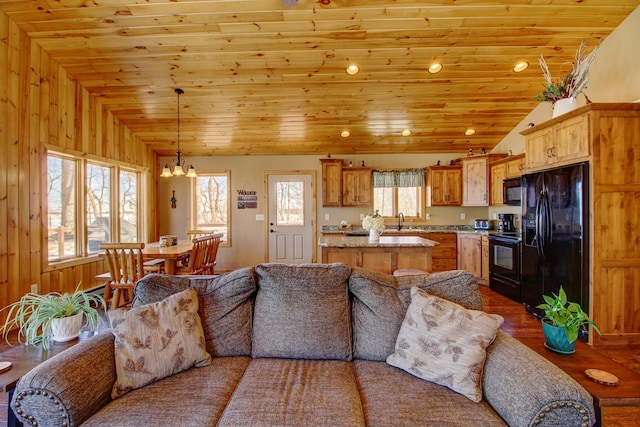living room featuring wood ceiling, lofted ceiling, and a notable chandelier