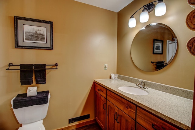 bathroom featuring toilet, visible vents, and vanity