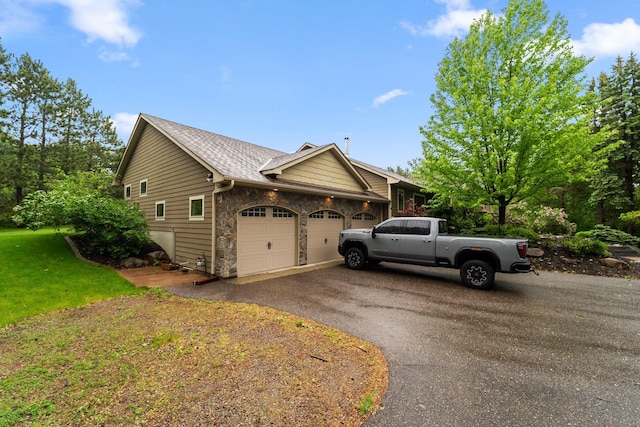 2650 Fox St, Orono, MN 55391 - view of side of property featuring a garage, asphalt driveway, stone siding, and a yard