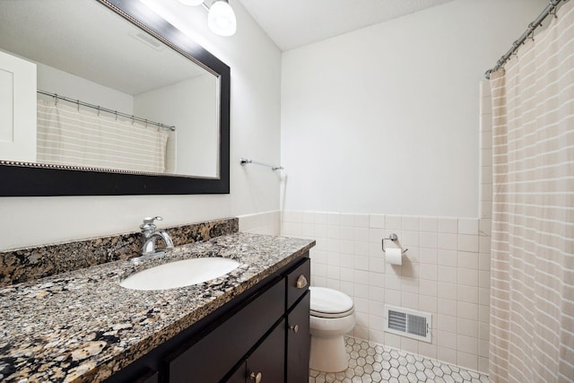 2650 Fox St, Orono, MN 55391 - full bathroom with vanity, toilet, tile walls, wainscoting, and tile patterned flooring