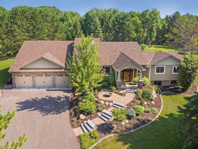 2650 Fox St, Orono, MN 55391 - view of front facade with stone siding, asphalt driveway, a front lawn, an attached garage, and covered porch