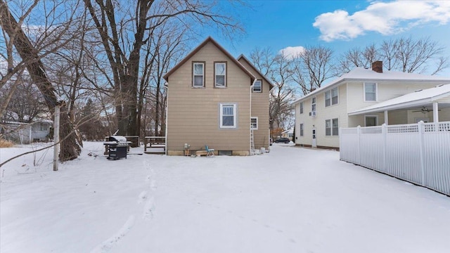 view of snow covered back of property