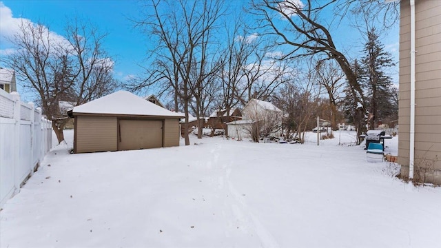 yard layered in snow with a garage and an outdoor structure