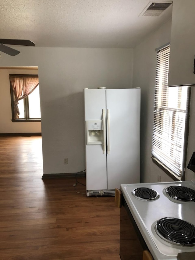 kitchen with a textured ceiling, range with electric stovetop, dark hardwood / wood-style floors, ceiling fan, and white refrigerator with ice dispenser