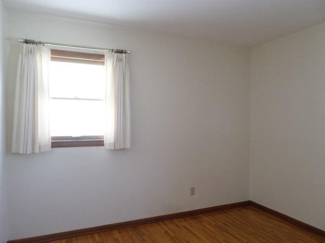 unfurnished room with dark wood-type flooring