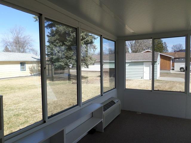 unfurnished sunroom featuring an AC wall unit