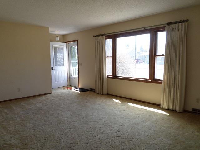 unfurnished room with carpet and baseboards