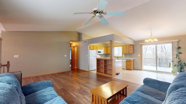 living room featuring ceiling fan with notable chandelier, lofted ceiling, dark hardwood / wood-style floors, and sink