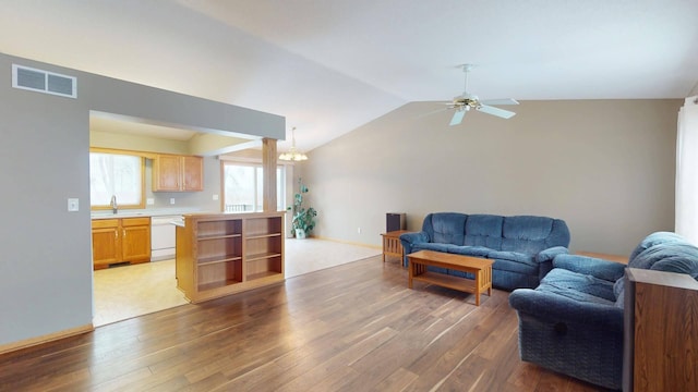 living room with dark hardwood / wood-style flooring, sink, ceiling fan with notable chandelier, and vaulted ceiling